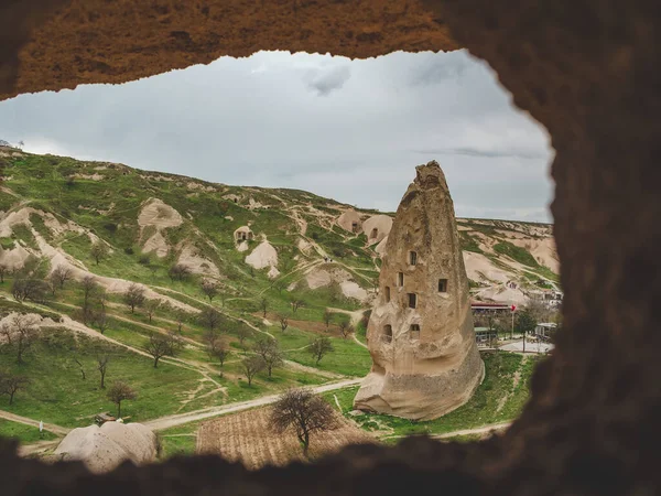 Wohnungen in den Felsen aus vulkanischem Tuff in türkischem Kappadokien Blick durch Steinbogen. Goreme-Nationalpark. — Stockfoto