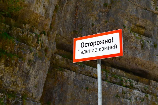 落石については山の中で警告標識 ロシア語からの翻訳 気をつけて — ストック写真