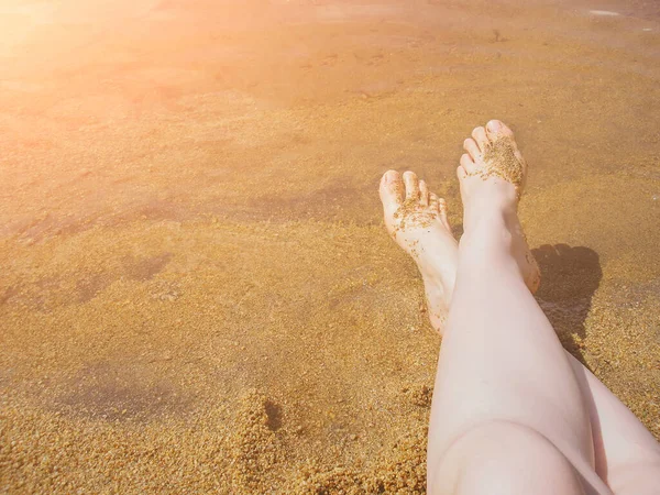 在湖畔的沙滩上 她的腿是光着脚 没有晒黑的 — 图库照片