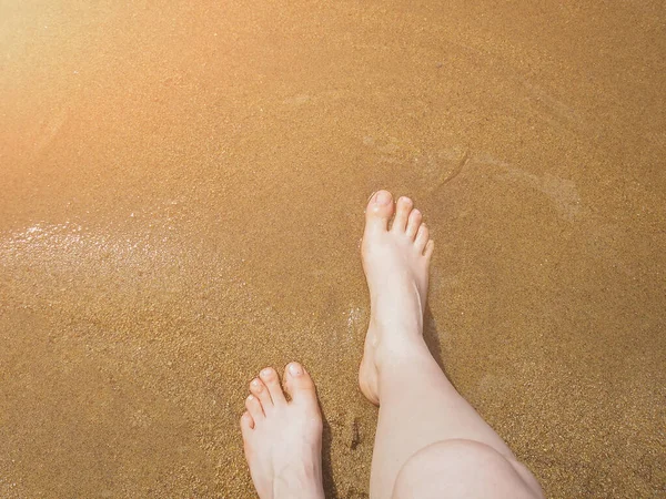 在湖畔的沙滩上 她的腿是光着脚 没有晒黑的 — 图库照片