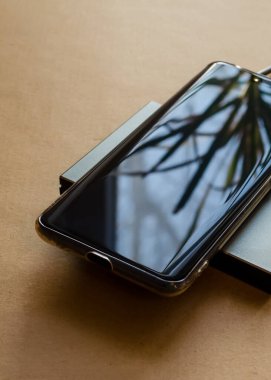 Telefon dikdörtgen endüksiyon şarj aletinden şarj oluyor. Kablosuz şarj cihazı.