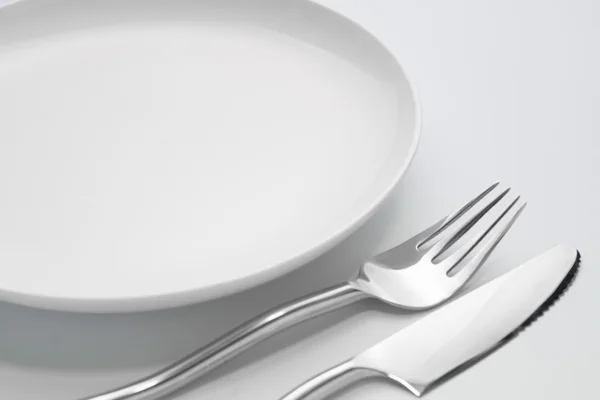 Piatto con forchetta e cucchiaio isolato — Foto Stock