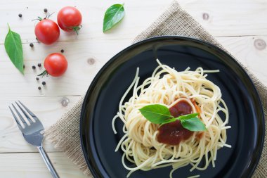 Spagetti domates fesleğen İtalyan otlar ile arka çanak üzerinde