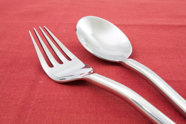 Tenedor y cuchara sobre mantel rojo — Foto de Stock