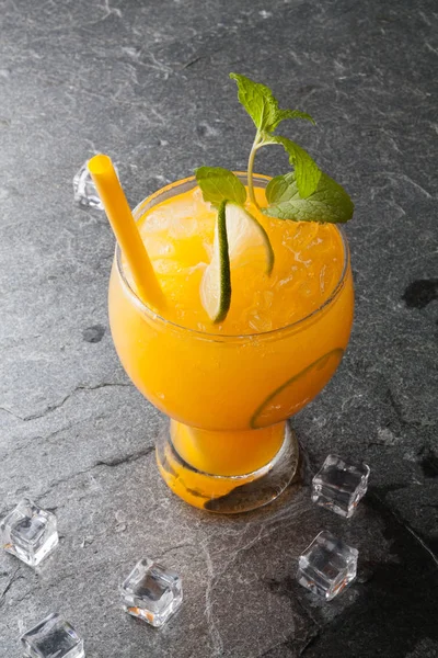 Апельсины и сок на каменном столе — стоковое фото