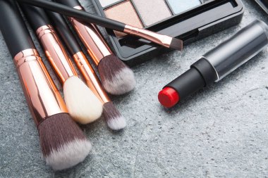 koyu arka plan üzerinde çeşitli makyaj ürünleri 