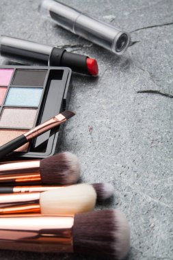koyu arka plan üzerinde çeşitli makyaj ürünleri 