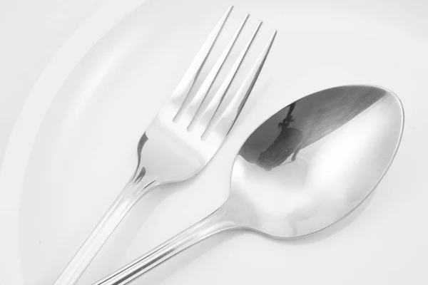 Tenedor y cuchara en un plato — Foto de Stock