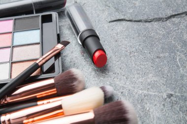 koyu arka plan üzerinde çeşitli makyaj ürünleri 