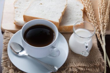 kahve fincanı ve masada kahve çekirdekleri