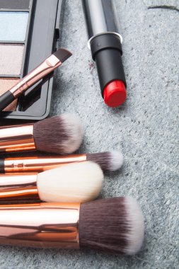koyu arka plan üzerinde çeşitli makyaj ürünleri 