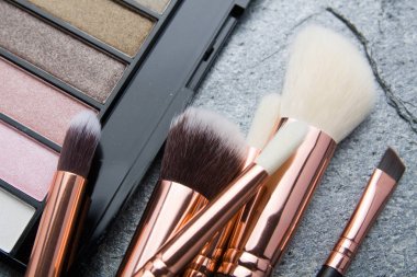 koyu arka plan üzerinde çeşitli makyaj ürünleri 