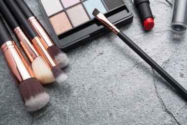 koyu arka plan üzerinde çeşitli makyaj ürünleri 