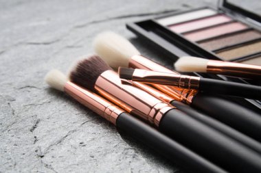 koyu arka plan üzerinde çeşitli makyaj ürünleri 