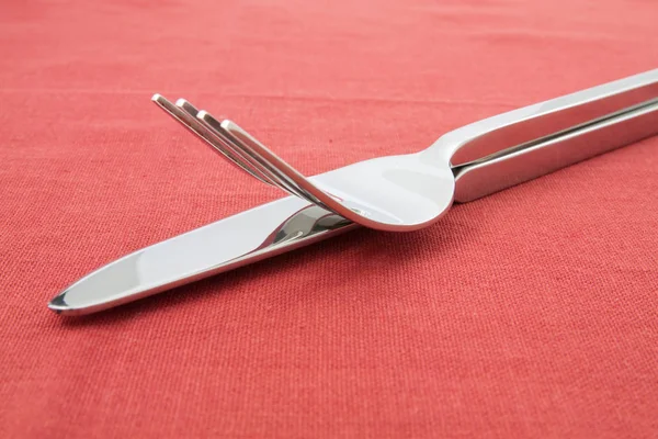 Gabel und Messer auf roter Tischdecke — Stockfoto