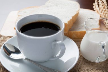 kahve fincanı ve masada kahve çekirdekleri