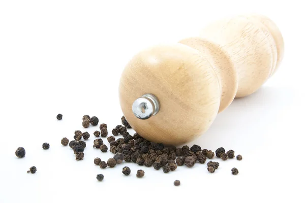 Pepper mill of wood with peppercorns — Stock Photo, Image