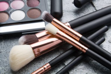 koyu arka plan üzerinde çeşitli makyaj ürünleri 