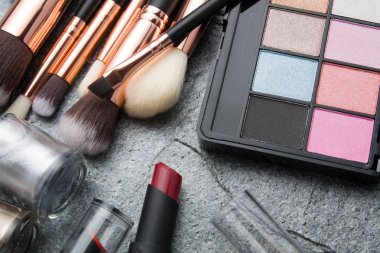 koyu arka plan üzerinde çeşitli makyaj ürünleri 