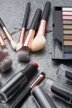 koyu arka plan üzerinde çeşitli makyaj ürünleri 