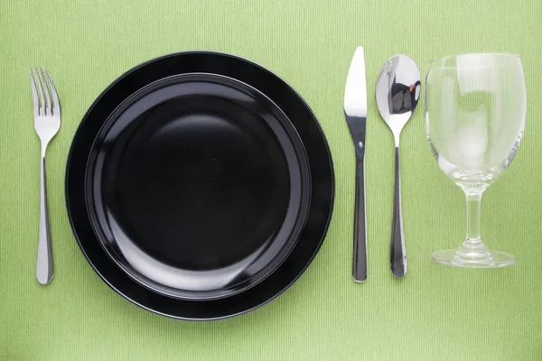 Placa negra en cuchillo de mesa y cuchara de tenedor — Foto de Stock