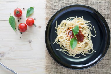 Spagetti domates fesleğen İtalyan otlar ile arka çanak üzerinde