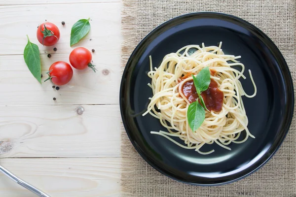 Spagetti domates fesleğen İtalyan otlar ile arka çanak üzerinde