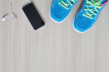 düz spor spor ayakkabı earphones ve telefon shot yatıyordu