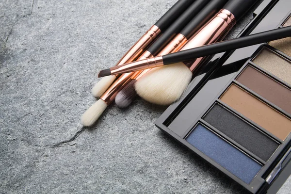 koyu arka plan üzerinde çeşitli makyaj ürünleri 