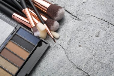 koyu arka plan üzerinde çeşitli makyaj ürünleri 