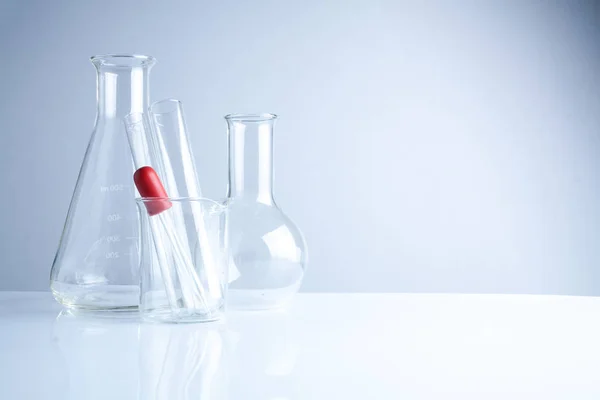 Laboratorní sklo na stůl, symbolických vědeckého výzkumu. — Stock fotografie