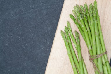 odun kesmenin üzerinde kuşkonmaz demet 