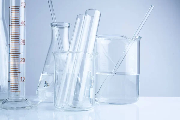 Vidrio de laboratorio sobre mesa, Simbólico de la investigación científica . —  Fotos de Stock