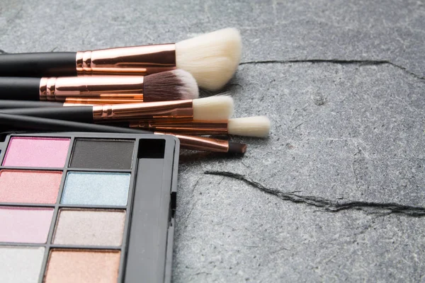 koyu arka plan üzerinde çeşitli makyaj ürünleri 
