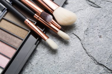 koyu arka plan üzerinde çeşitli makyaj ürünleri 