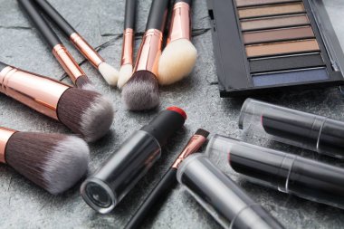 koyu arka plan üzerinde çeşitli makyaj ürünleri 