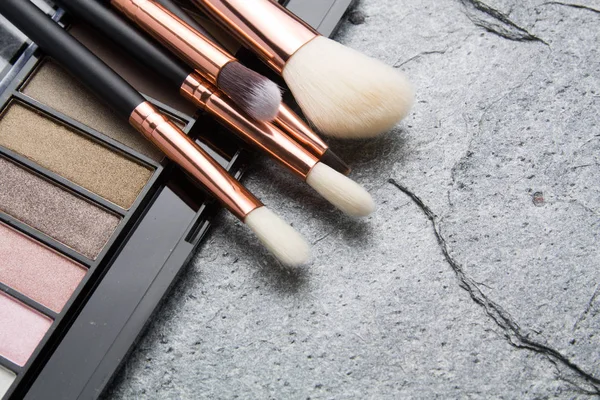 koyu arka plan üzerinde çeşitli makyaj ürünleri 