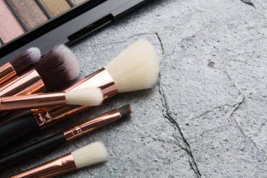 koyu arka plan üzerinde çeşitli makyaj ürünleri 