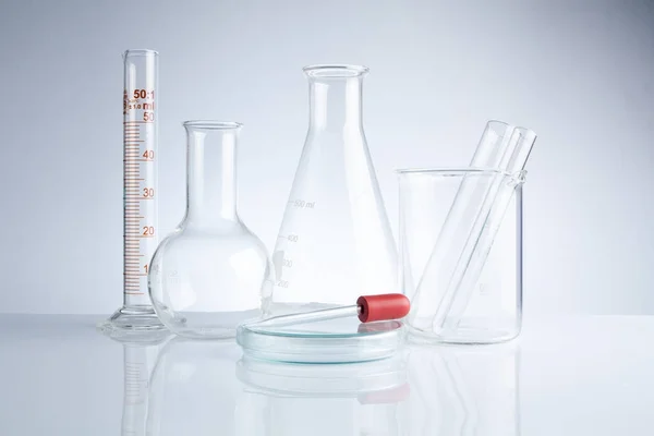Vetreria da laboratorio in tavola, Simbolica della ricerca scientifica . — Foto Stock