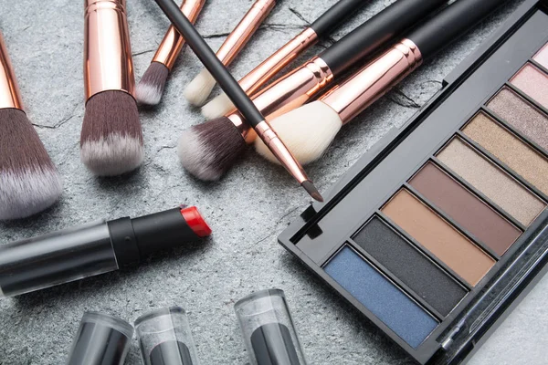 koyu arka plan üzerinde çeşitli makyaj ürünleri 