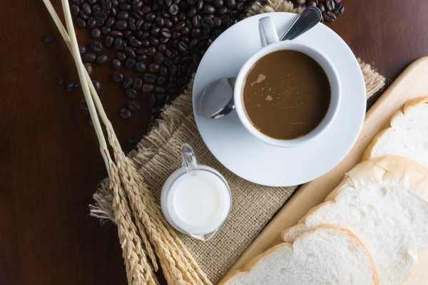 Crujientes cruasanes frescos y una taza de café expreso en una w rústica —  Fotos de Stock