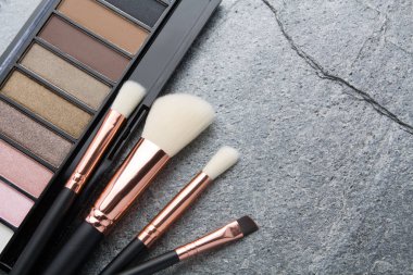 koyu arka plan üzerinde çeşitli makyaj ürünleri 