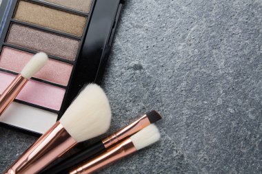 koyu arka plan üzerinde çeşitli makyaj ürünleri 