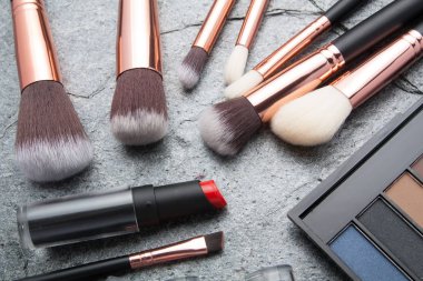 koyu arka plan üzerinde çeşitli makyaj ürünleri 