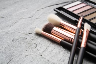 koyu arka plan üzerinde çeşitli makyaj ürünleri 