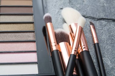 koyu arka plan üzerinde çeşitli makyaj ürünleri 