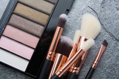 koyu arka plan üzerinde çeşitli makyaj ürünleri 