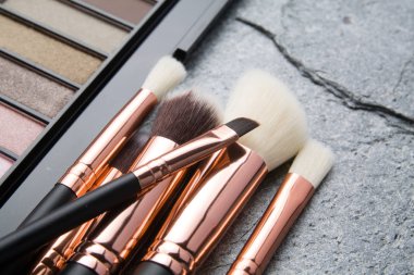 koyu arka plan üzerinde çeşitli makyaj ürünleri 