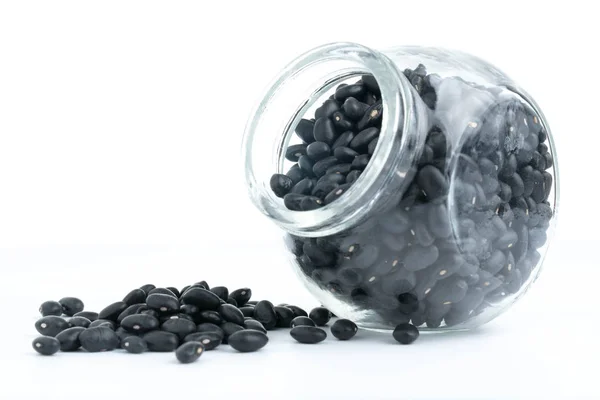 Black beans on glass bottles with white — Stock Photo, Image
