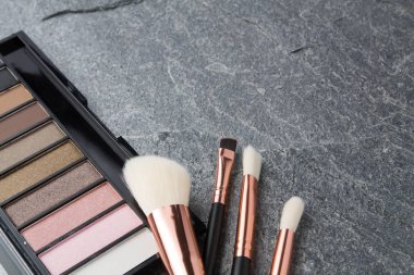 koyu arka plan üzerinde çeşitli makyaj ürünleri 